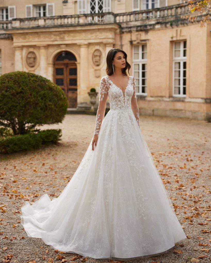rosa clara_brautatelier ried_vashni_1R116_prinzessin_all-over spitze_v-ausschnitt_aermel_spitzenrock_ivory-nude_vorne_1-min